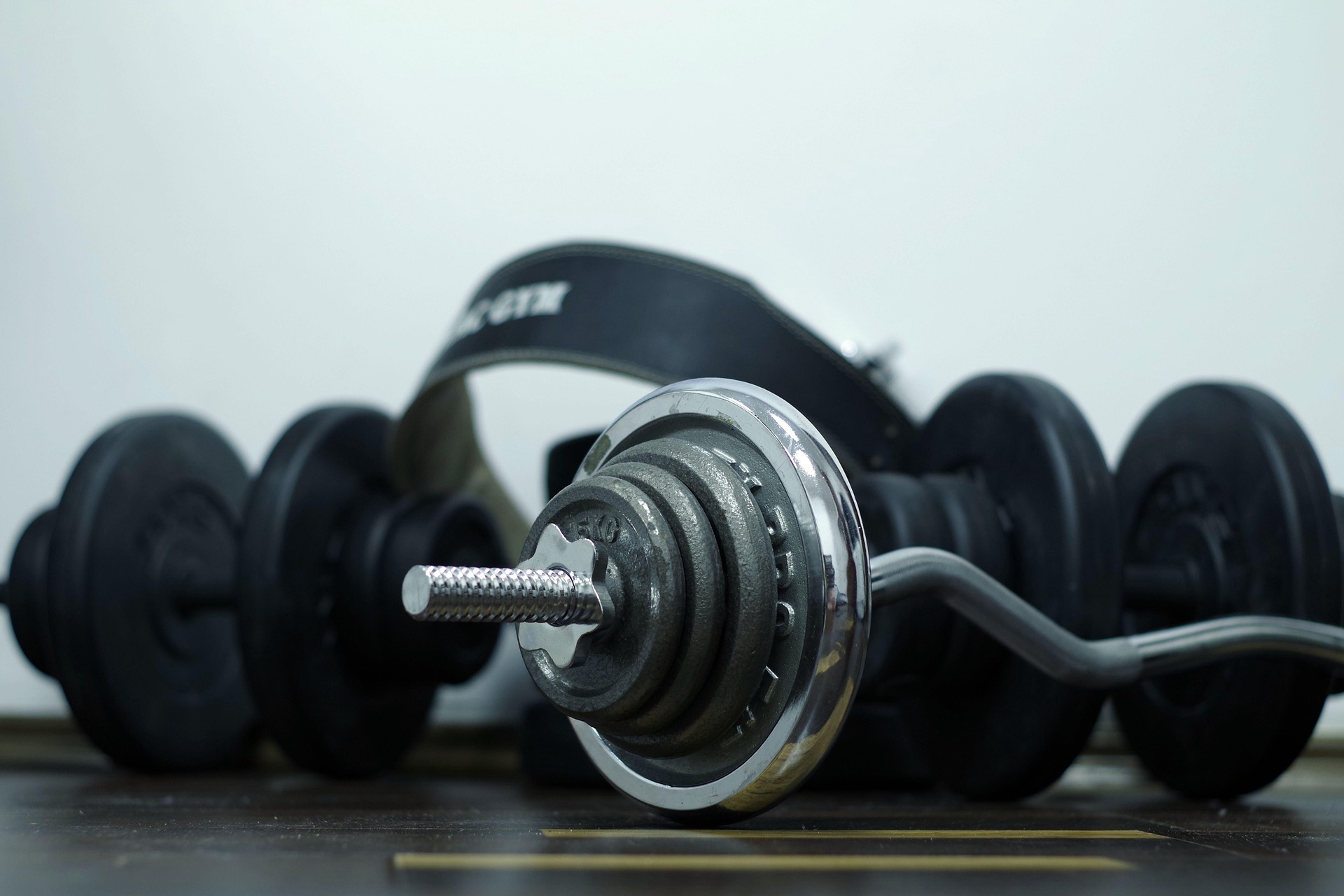 Dumbbells and a barbell on a gym floor